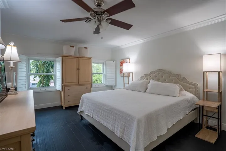 Bedroom with dark wood-type flooring, a ceiling fan, baseboards, and ornamental molding