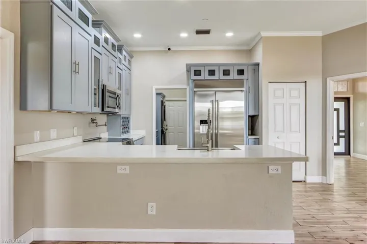 Kitchen featuring light gray cabinetry, stainless steel appliances, white countertops, built-in microwave, and recessed lighting