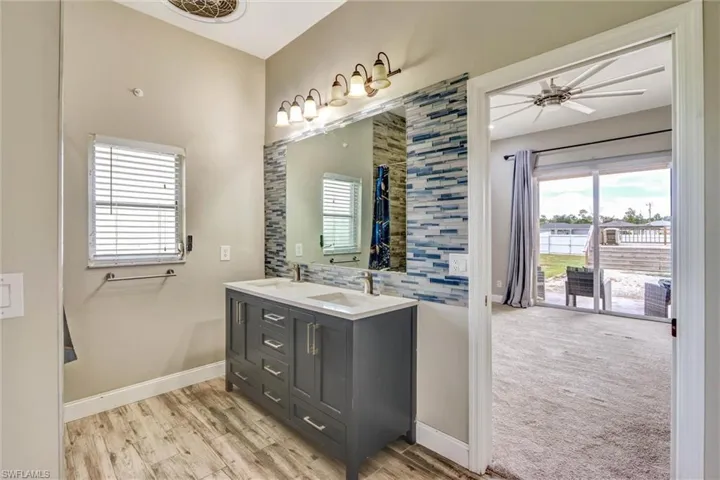Dual vanity featuring a white countertop, two undermount sinks, and a mosaic tile backsplash