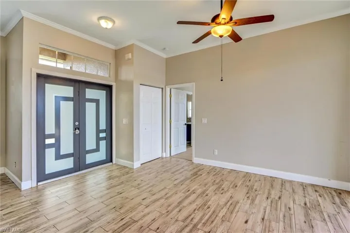 Entry foyer featuring double doors with frosted glass inserts, a transom window above, and wood-finish tile flooring