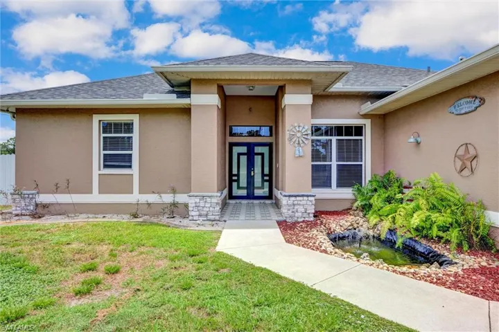 Stucco exterior with stone accent columns and a covered entry