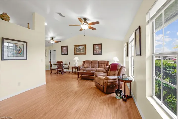 Living room featuring light wood look flooring + a healthy amount of sunlight