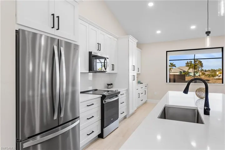 GORGEOUS CHEF'S KITCHEN w/ SPACIOUS QUARTS COUNTERTOP ISLAND w/ undermount LARGE SINK & SLEEK MATTE-BLACK gooseneck FAUCET.