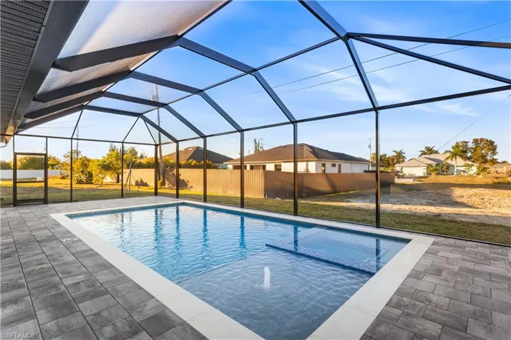 Step outside to SCREENED LANAI w/ HEATED POOL & SPA, landscaped surrounding