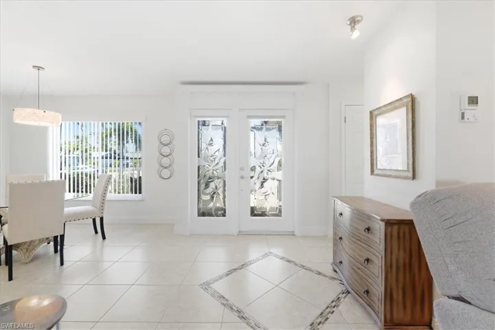 Entrance foyer featuring light tile patterned floors and inlaid floor details