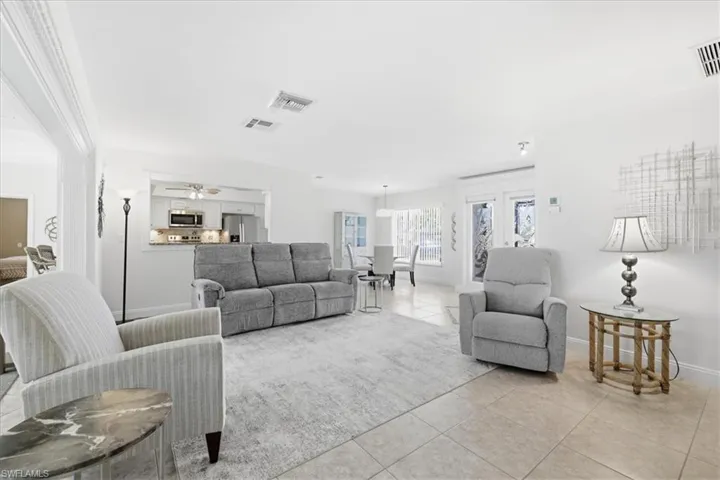 Living area with light tile patterned floors and a ceiling fan