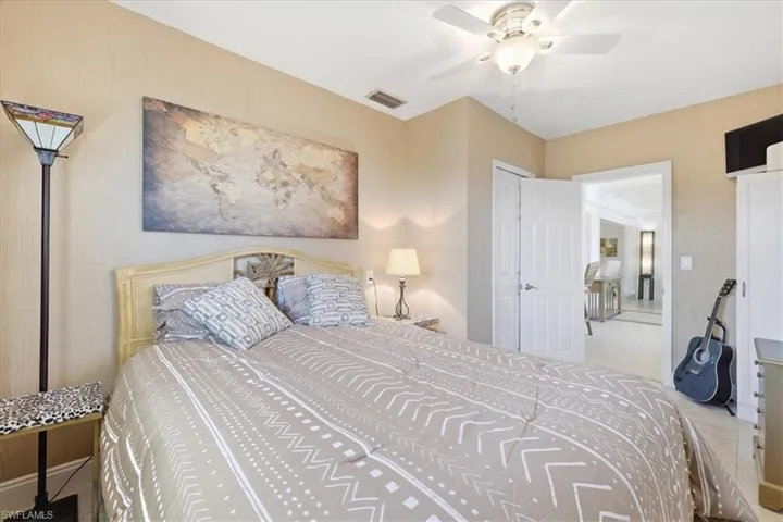 Tiled bedroom featuring a ceiling fan and baseboards