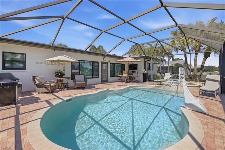 Swimming pool with glass enclosure, a patio area