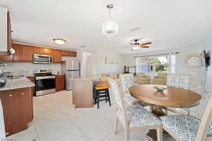 Dining area featuring ceiling fan and light marble finish flooring