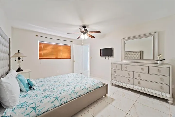 Bedroom with light marble finish floors and ceiling fan