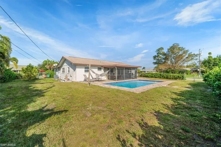 View of swimming pool featuring a sunroom and a yard