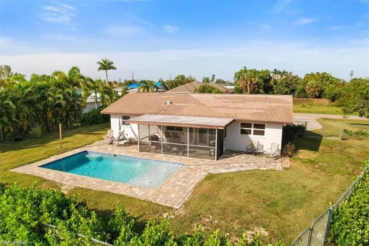 Back of house featuring a sunroom, an outdoor pool, a patio, and stucco siding