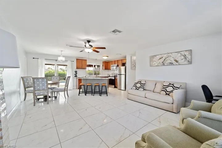 Living area with light marble finish floors and a ceiling fan