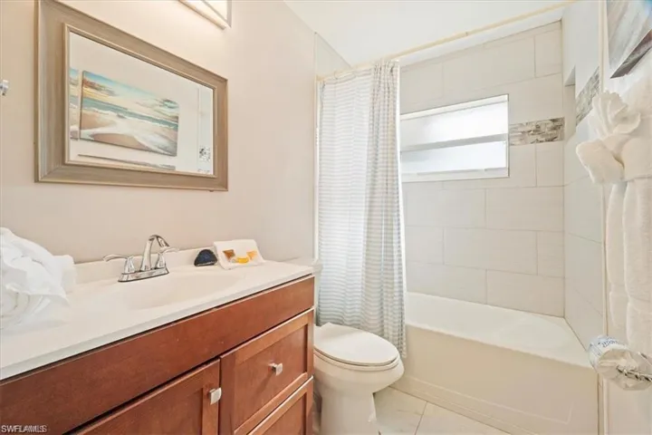 Bathroom featuring toilet, vanity, and shower / bath combo with shower curtain