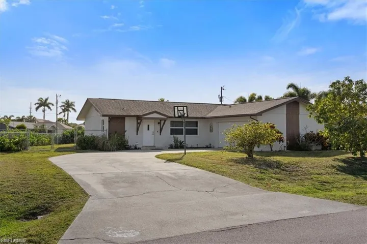 View of front of home with driveway and a front lawn