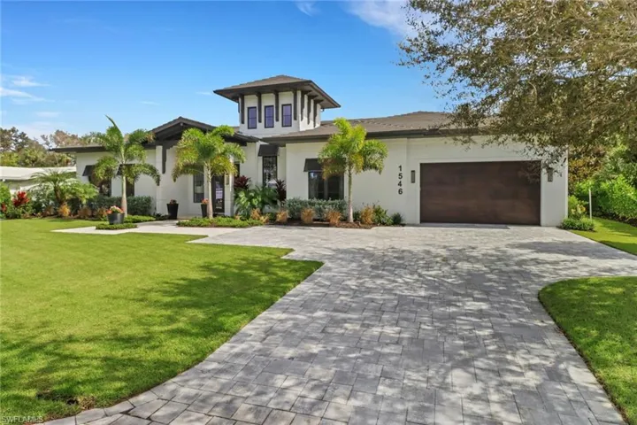 View of front of property with a front yard and a garage