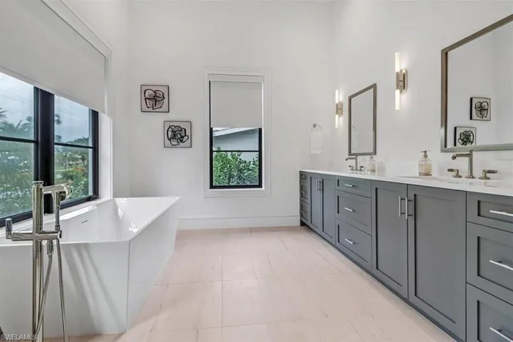 Bathroom with a bathtub, tile patterned flooring, and vanity