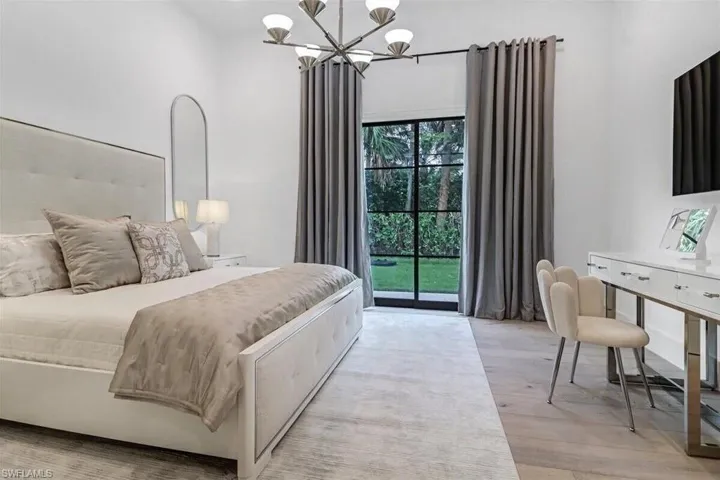Bedroom featuring a chandelier, light hardwood / wood-style flooring, and access to outside