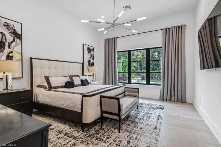 Bedroom featuring a notable chandelier and light hardwood / wood-style floors