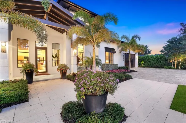 Patio terrace at dusk featuring decorative driveway and an attached garage