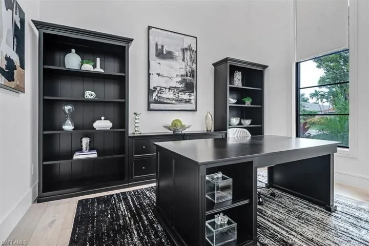 Office area with wood-type flooring and built in shelves