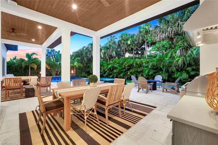 View of patio featuring outdoor dining area, an outdoor pool, ceiling fan, and a grill