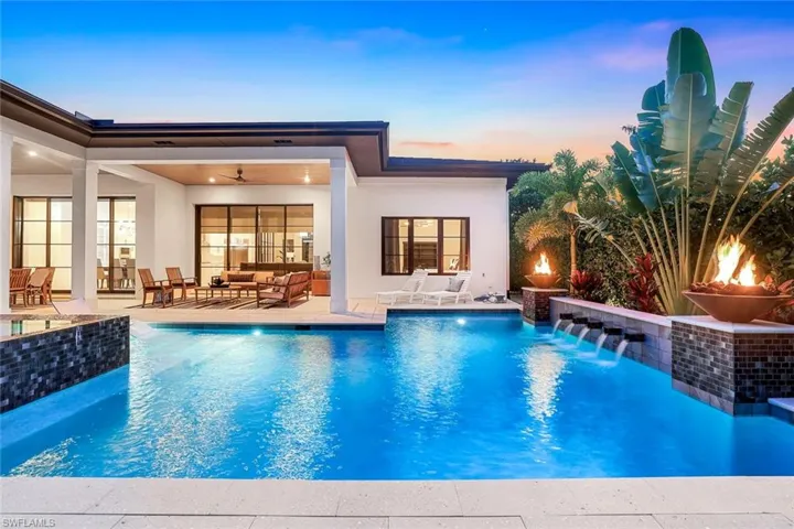 Pool at dusk featuring an outdoor pool, a patio area, and an outdoor living space