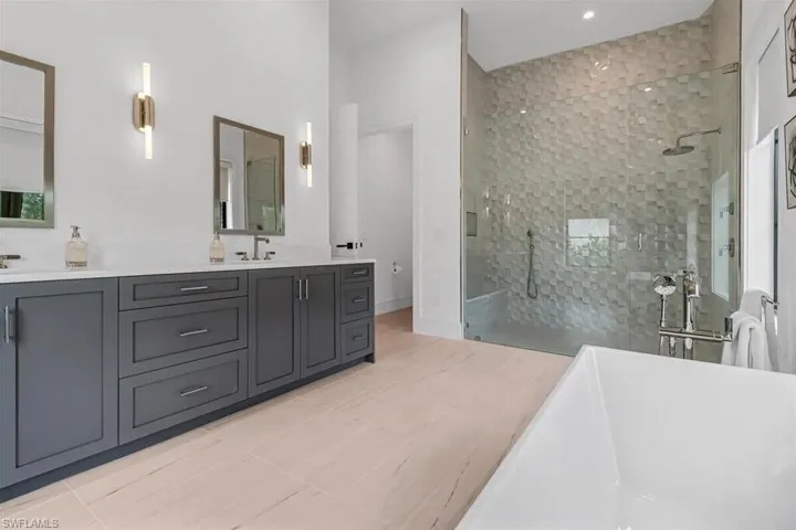Bathroom featuring vanity, tile patterned floors, and tiled shower