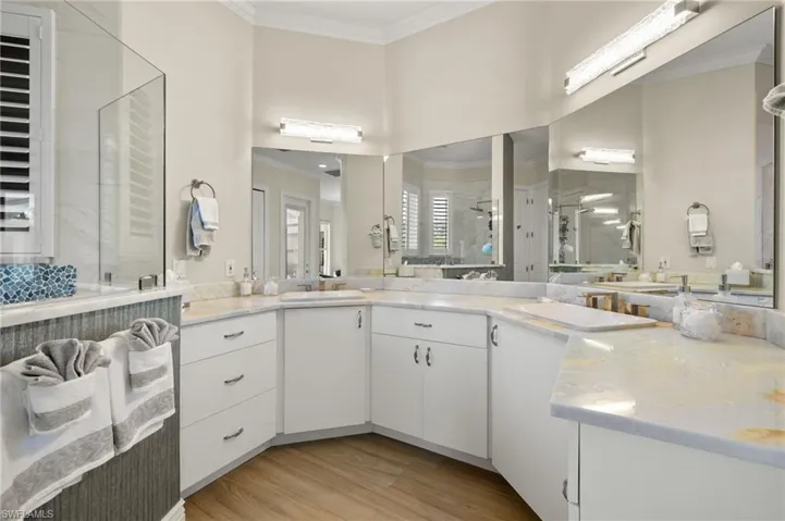 Bathroom featuring crown molding, wood-type flooring, vanity, and an enclosed shower
