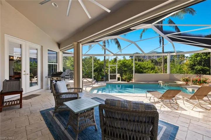 View of pool featuring glass enclosure, french doors, and a patio area