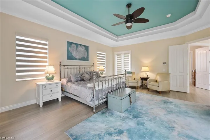 Bedroom with multiple windows, hardwood / wood-style floors, and ceiling fan