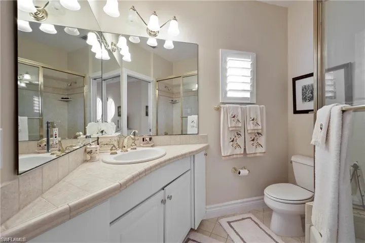 Bathroom with vanity, toilet, tile patterned floors, and a shower with door