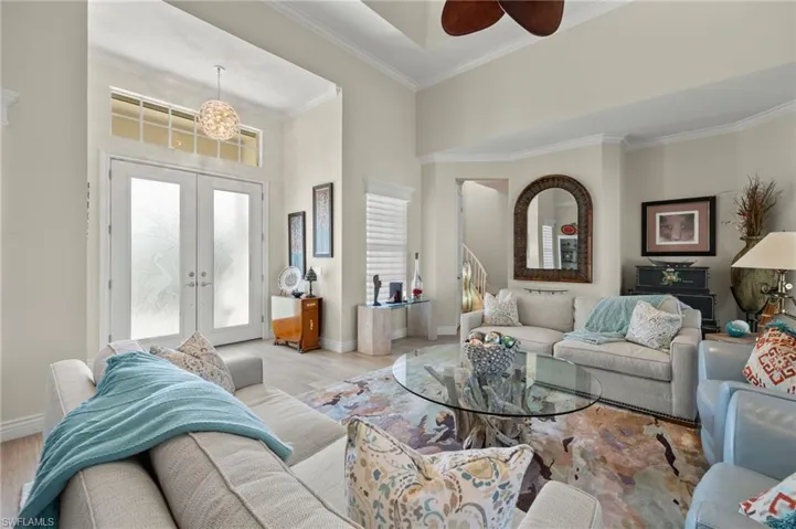 Living room featuring ceiling fan, ornamental molding, french doors, and light hardwood / wood-style floors