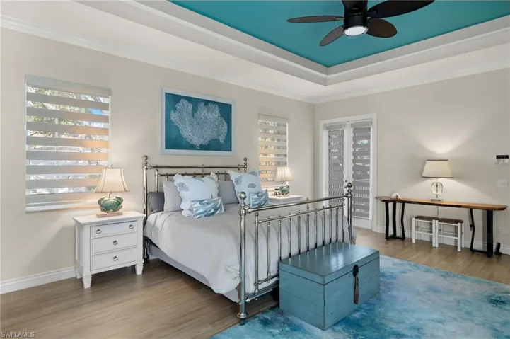 Bedroom featuring ornamental molding, wood-type flooring, multiple windows, and ceiling fan