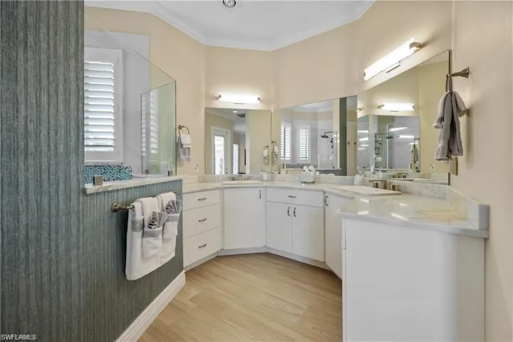 Bathroom featuring crown molding, vanity, and hardwood / wood-style flooring