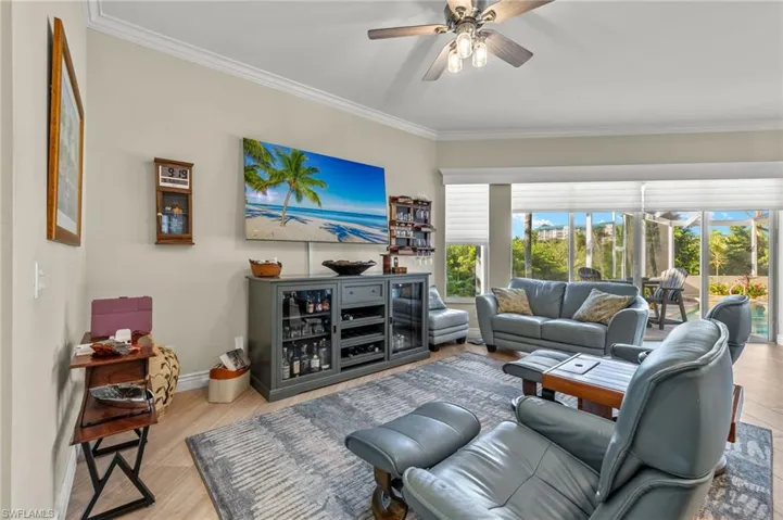Living room with ceiling fan, light hardwood / wood-style flooring, and crown molding