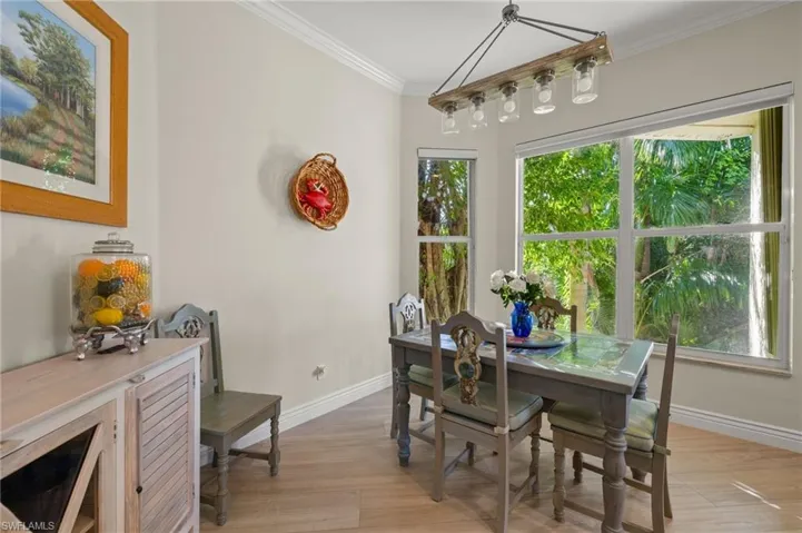 Dining space featuring ornamental molding, light hardwood / wood-style flooring, and plenty of natural light