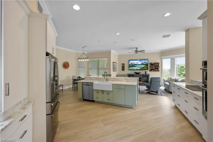 Kitchen featuring stainless steel appliances, white cabinetry, a center island with sink, and sink