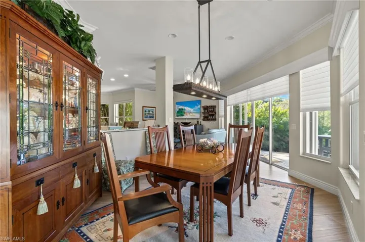 Dining room with light hardwood / wood-style flooring and ornamental molding