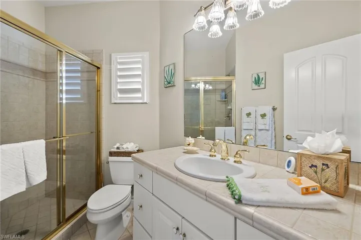 Bathroom with vanity, tile patterned flooring, toilet, and an enclosed shower