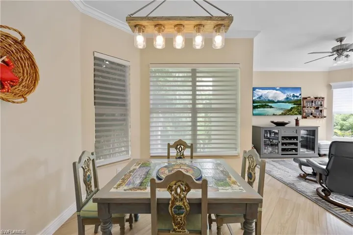 Dining area featuring ceiling fan, ornamental molding, and light hardwood / wood-style floors
