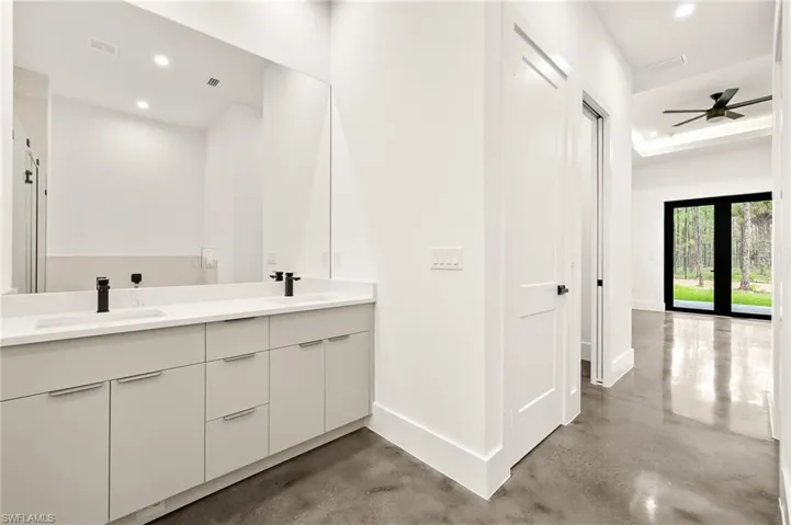 Bathroom with a sink, recessed lighting, and finished concrete flooring