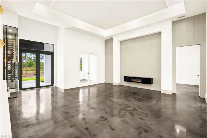 Unfurnished living room with finished concrete floors, visible vents, and a raised ceiling
