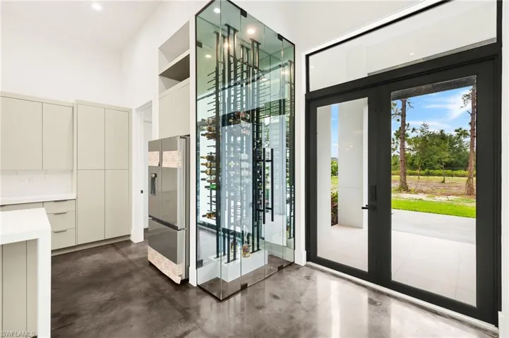 Wine room featuring concrete floors and french doors
