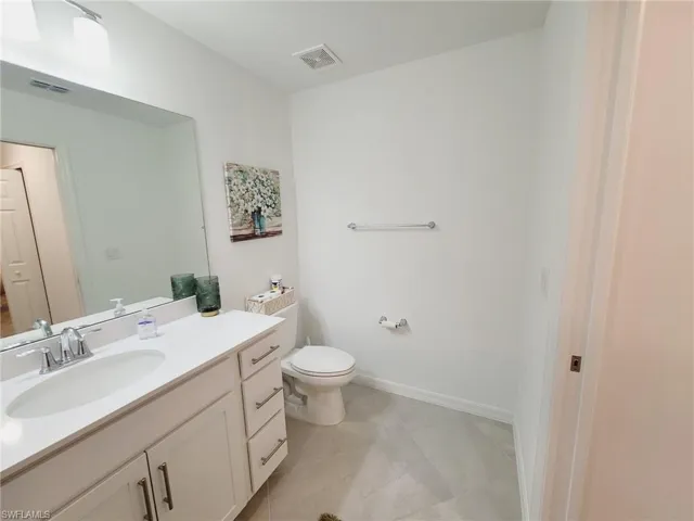 Bathroom featuring tile patterned flooring, vanity, and toilet