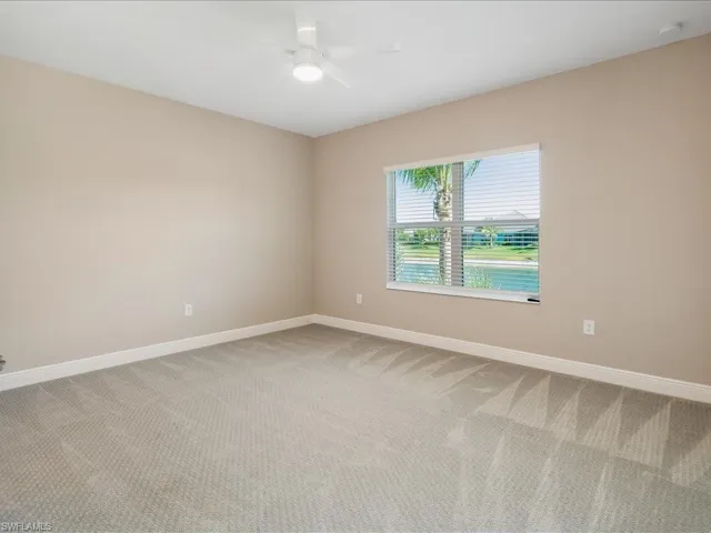 Wall-to-wall carpeting, neutral wall color, and a ceiling fan with integrated lighting