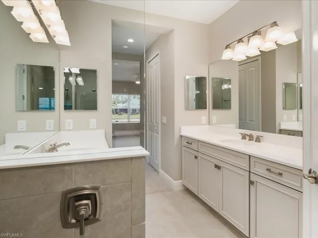Dual vanity with light-toned cabinetry, brushed nickel hardware, and individual mirrors
