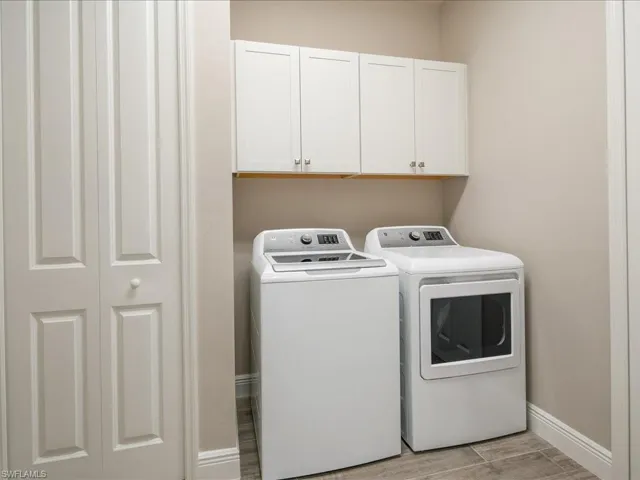 Built-in overhead white cabinetry, wood-finish flooring, and a paneled bifold door