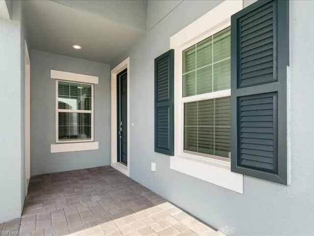 Covered entry with paver flooring, recessed lighting, and a paneled entry door