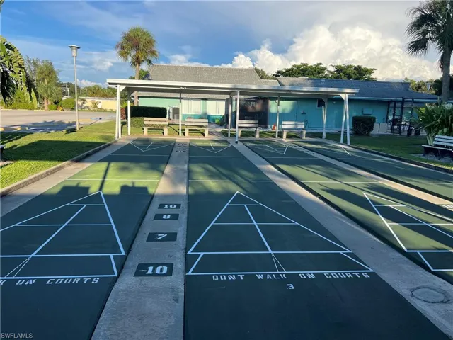 View of community with a yard, a patio, and shuffleboard